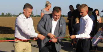 Przewodniczący Rady Gminy Stare Pole, Wójt Gminy Stare Pole oraz Sołtys wsi Kaczynos-Kolonia przecinają wstęgę podczas otwarcia placu zabaw