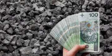 Plik pieniędzy w dłoni na tle węgla